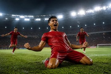Pemain merayakan gol di stadion pada malam hari
